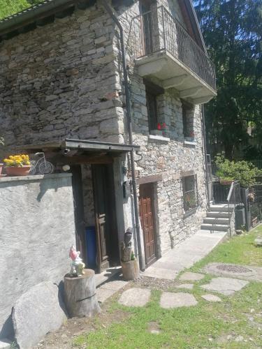 a stone building with a door and a balcony at Casa Prucci in Battigio