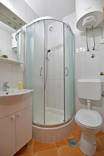 a bathroom with a shower and a toilet and a sink at Apartments Mićić in Hvar