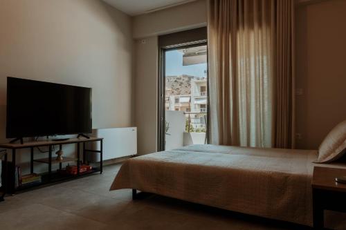 Un dormitorio con una cama y una ventana grande. en Dantis Place Alpha2, en Nauplia