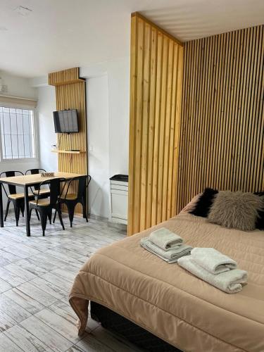 a bedroom with a bed and a table and a dining room at HolaCentro in General Roca