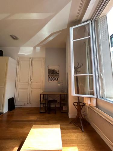 un salon avec une table et une fenêtre dans l'établissement Studio de charme 20m2 à Saint-Mandé, à Saint-Mandé