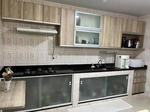 una cucina con armadi in legno e ripiani neri di Casa em Anchieta completa próximo a castelhanos e Iriri a Anchieta