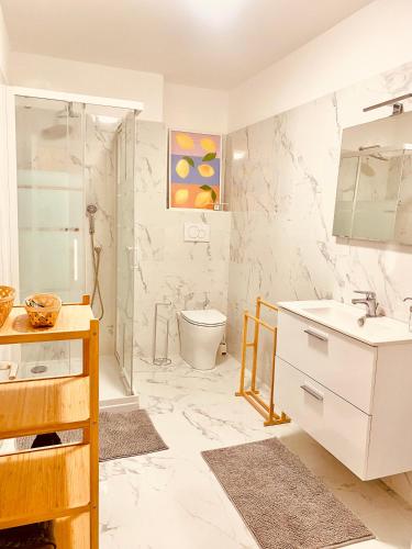 une salle de bain avec un lavabo, une douche et des toilettes dans l'établissement Au coin du pin, à Menton