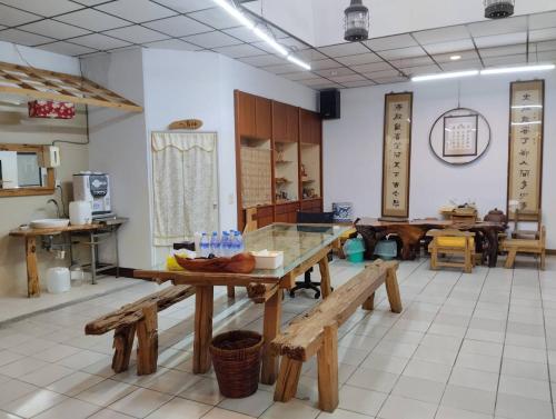 a room with a table and benches in a room at Huang's Guesthouse in Chishang