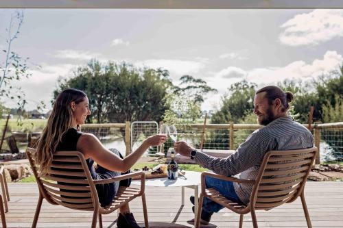 a man and woman sitting at a table drinking wine at Birdnest Galah in Witchcliffe
