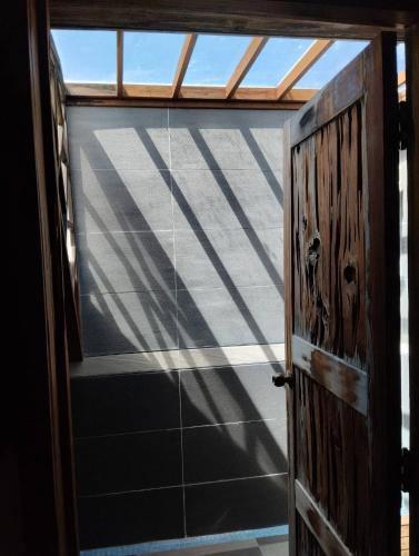 an open door with the shadows of a roof at Huang's Guesthouse in Chishang