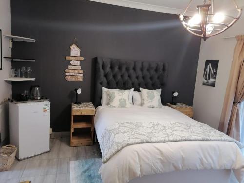 a bedroom with a large bed with a black headboard at At30 OverNite Stay in Potchefstroom