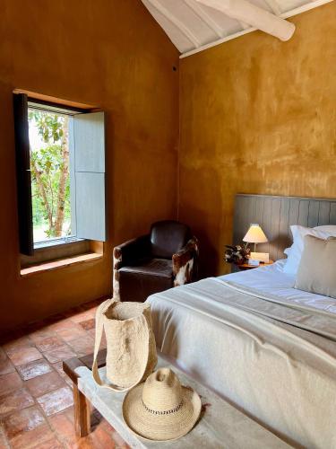 a bedroom with a bed and a chair with a hat on a table at Terrazul Barichara in Barichara