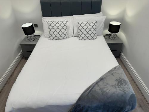 a bedroom with a large white bed with two lamps at Harrington Street Apartments Liverpool by Beehosting in Liverpool