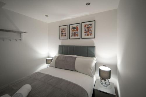 a bedroom with a bed and three pictures on the wall at Harrington Street Apartments Liverpool by Beehosting in Liverpool