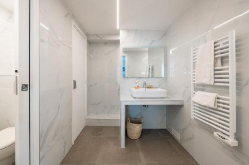 une salle de bain blanche avec un lavabo et un miroir dans l'établissement 50m2 rue rambuteau/Pompidou/Marais/Hôtel de Ville, à Paris