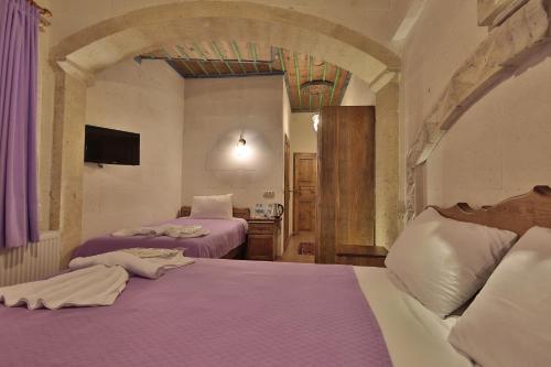 a bedroom with two beds with purple sheets at Relic House in Goreme