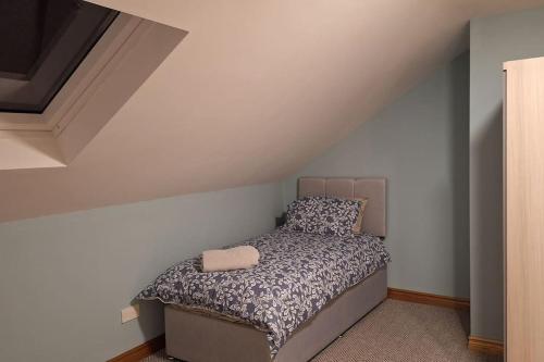 a small bedroom with a bed with a pillow at Ballnamona house in Cong