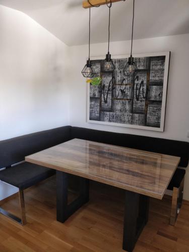 a dining room table with a bench and a picture at Kurort Tirol in Bad Häring