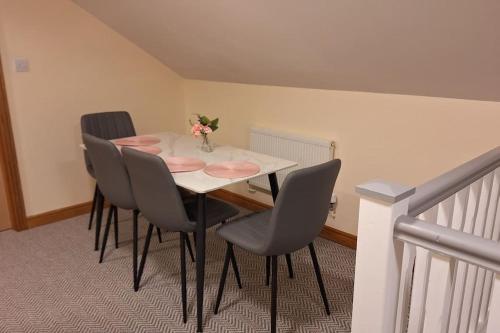 a dining room table with chairs and a vase of flowers on it at Ballnamona house in Cong