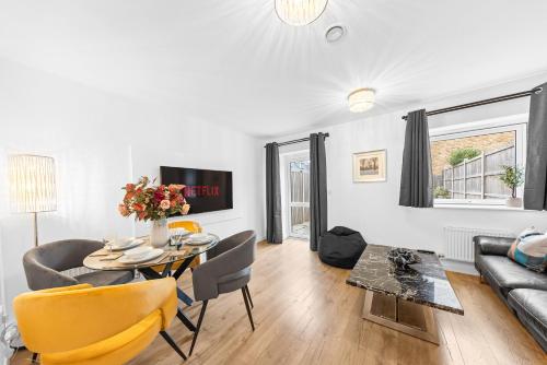 a living room with a table and a couch at THE OAK - An Elegant 2 Bedroom House in Dartford - London Zone 8 in Dartford