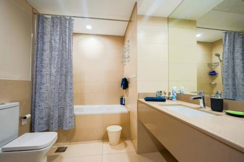a bathroom with a toilet and a sink and a tub at Family Escape 3BR plus Maids Elegant Yas Island907W4 in Abu Dhabi