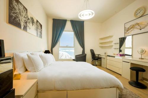 a bedroom with a bed and a desk and a window at Family Escape 3BR plus Maids Elegant Yas Island907W4 in Abu Dhabi
