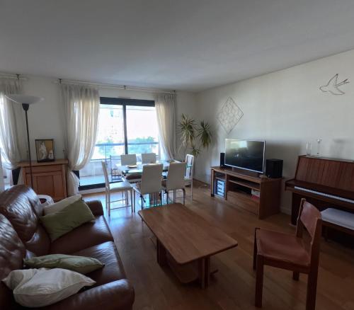 un salon avec un canapé et une table dans l'établissement Superbe appartement Paris Courbevoie La Défense, à Courbevoie