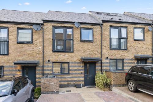 a brick house with two cars parked in front of it at THE OAK - An Elegant 2 Bedroom House in Dartford - London Zone 8 in Dartford
