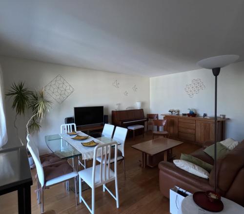 un salon avec une table, des chaises et un canapé dans l'établissement Superbe appartement Paris Courbevoie La Défense, à Courbevoie