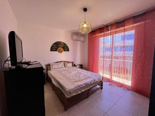 une chambre avec un lit, une télévision et une fenêtre dans l'établissement Chau, à Valras-Plage