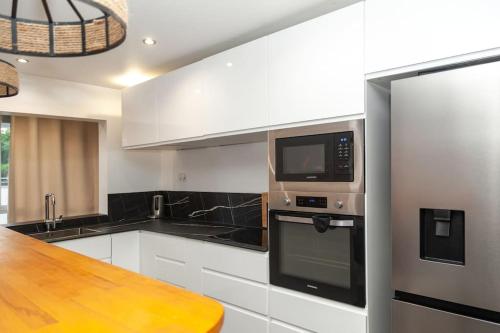 une cuisine avec des appareils en noir et blanc et un comptoir en bois dans l'établissement Appartement Paris - La Défense, à Nanterre