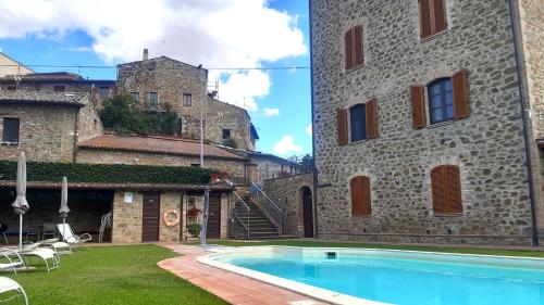 ein Haus mit einem Swimmingpool vor einem Gebäude in der Unterkunft Le Rondini in Torricella