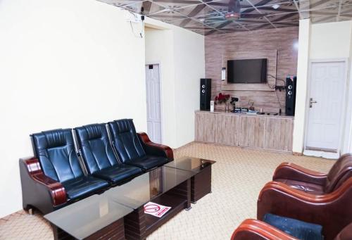 a living room with two leather chairs and a television at Travel Nexus in Gilgit