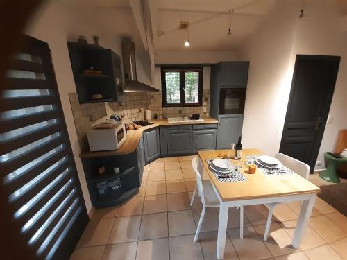 - une cuisine avec une table, une table et des chaises dans l'établissement Maison gîte studio de vacances sud de la France, à Cuzac