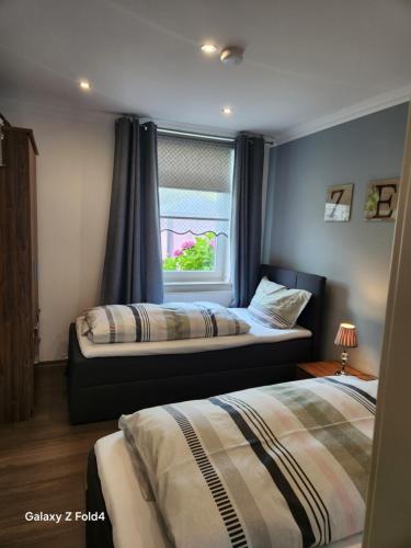 a bedroom with two beds and a window at Ferienwohnung Rose in Wilhelmshaven