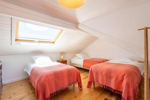 Zimmer im Dachgeschoss mit 2 Betten und einem Fenster in der Unterkunft Charming Beach House - by Smarthomes in São Martinho do Porto