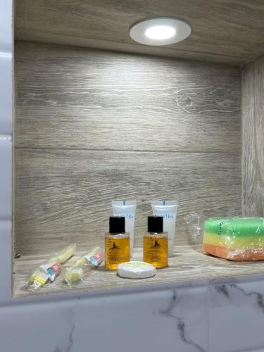 a shelf with three bottles of soap and toothpaste at Moonlight Apart-Hotel Batumi in Batumi