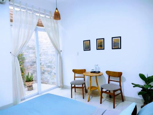 a room with a table and chairs and a window at Nạp Homestay in Kinh Dinh
