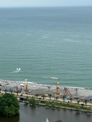 an amusement park with a roller coaster and a beach at Moonlight Apart-Hotel Batumi in Batumi