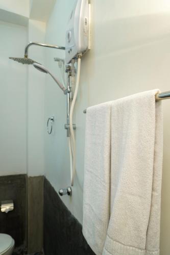 a bathroom with a white towel hanging on the wall at Vendol Lake Resort - Kandy in Kandy