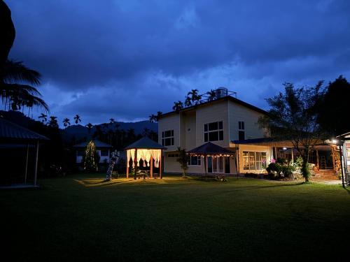 a house with a lit up yard at night at Shuizhong Yue Homestay in Guoxing
