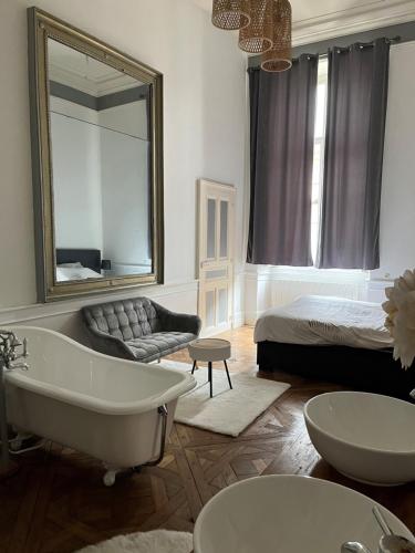 bagno con vasca, letto e specchio di Appartement au Palais - WIFI a Moulins