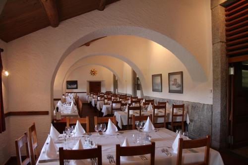 een eetkamer met witte tafels en stoelen bij Albergo San Gottardo in Airolo