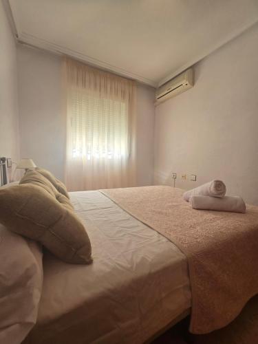 a bedroom with a bed with two towels on it at Bungalow Brisa de Mar in Torrevieja
