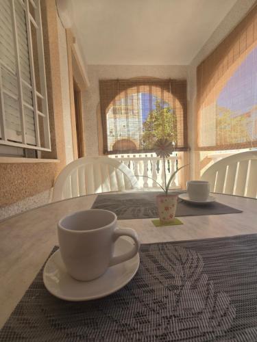 een tafel met een beker en een bord erop bij Bungalow Brisa de Mar in Torrevieja