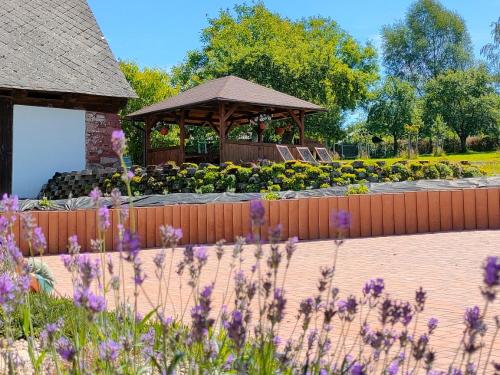 a garden with a gazebo and flowers at Apartmány Slavíkov - Simple Suite in Horní Radechová