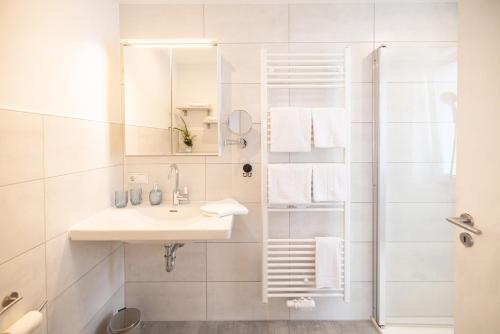 a white bathroom with a sink and a shower at Apartment Wasenberg in Willingshausen