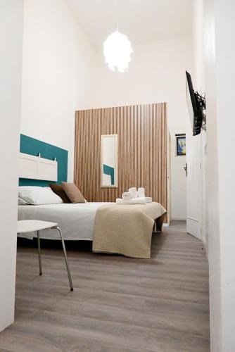 a bedroom with a large bed and a table at Fatata Suites in Lecce