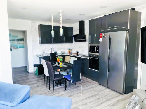 eine Küche mit einem Tisch mit Stühlen und einem Kühlschrank in der Unterkunft Apartamento Las Mercedes - Playa in Torremolinos