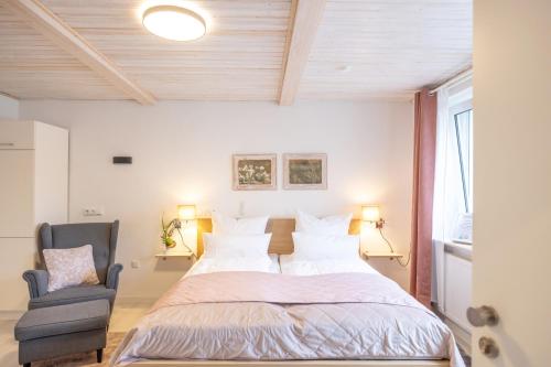 a bedroom with a large bed and a chair at Apartment Wasenberg in Willingshausen