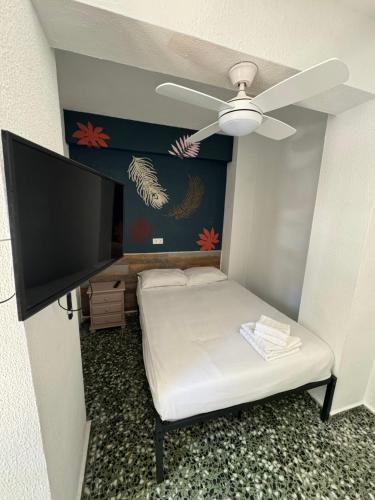 a small bedroom with a bed and a ceiling fan at Pension RIOKA CALPE in Calpe