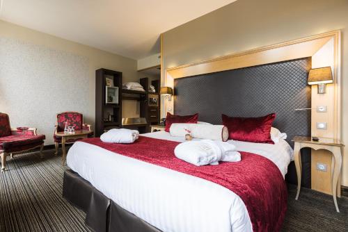 a hotel room with a large bed with red pillows at Plaza Madeleine & Spa in Sarlat-la-Canéda
