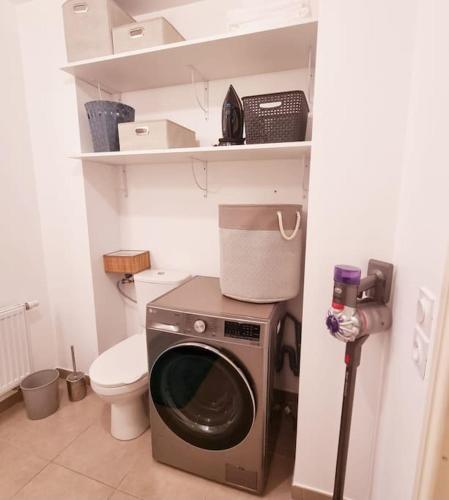 une salle de bain avec machine à laver et toilettes dans l'établissement Ce jolie appartement de 45 m2, à Perpignan
