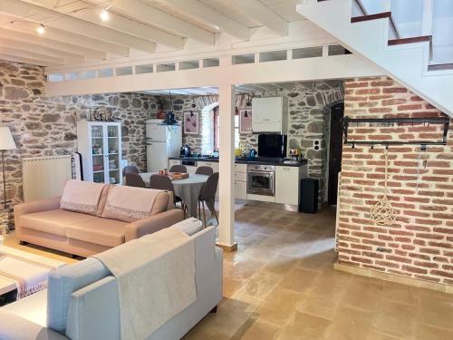 a living room with a couch and a brick wall at Dreamy Cottage in Ayiá